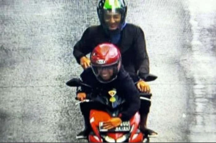 Pengendara Yamaha Aerox 155 yang berboncengan mencoba klabui petugas menutup pelat nomor menggunakan tangan