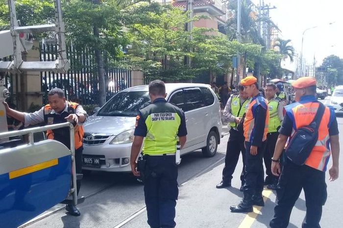 Sejumlah petugas menderek mobil Toyota Avanza yang nekat parkir di atas perlintasan kereta api di jalan Mayor Sunaryo, Solo, Jawa Tengah 