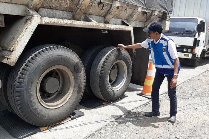 Kepala Manajemen Lalulintas Area 2 Seksi Semarang - Cirebon Jasa Marga Transjawa Toll, Agus Hartoyo, saat mengecek kondisi ban kendaraan besar dalam razia ODOL di Rest Area KM 208 Tol Palimanan - Kanci (Palikanci), Kecamatan Mundu, Kabupaten Cirebon, Rabu (26/2/2020).   