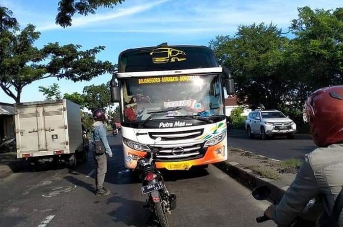 Seorang pria nekat menghadang laju bus antar kota yang salah jalur di Jalan Raya Duduksampeyan, Gresik.(instagram infogresik)