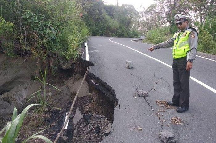 Polisi ketika melakukan pengecekan jalan ambles di jalur Culali, Dusun Yeh Mampeh, Desa Batur Selatan, Kintamani, Bangli, Bali.