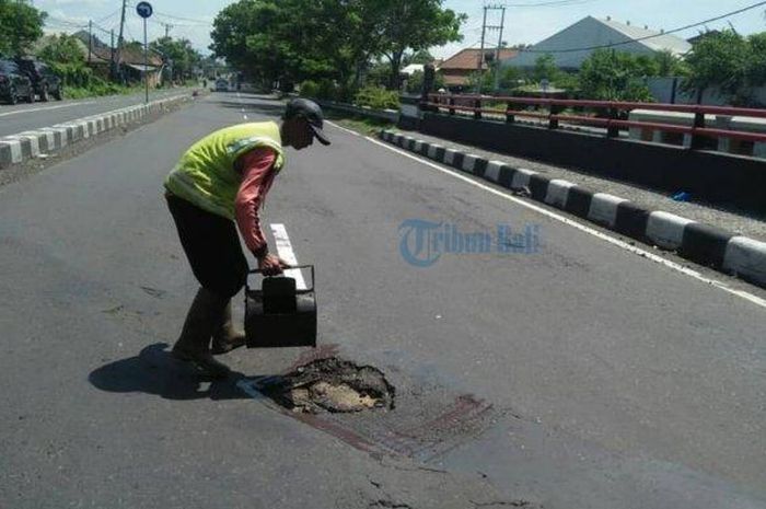 Balai Jalan Provinsi Bali menambal jalan berlubang yang berada di Bypass Ida Bagus Mantra, Gianyar, Bali