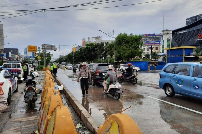 Kasi Gar Subdit Gakkum&nbsp;Ditlantas Polda Metro Jaya Kompol Tri Waluyo saat mengatur lalu lintas ditengah hujan