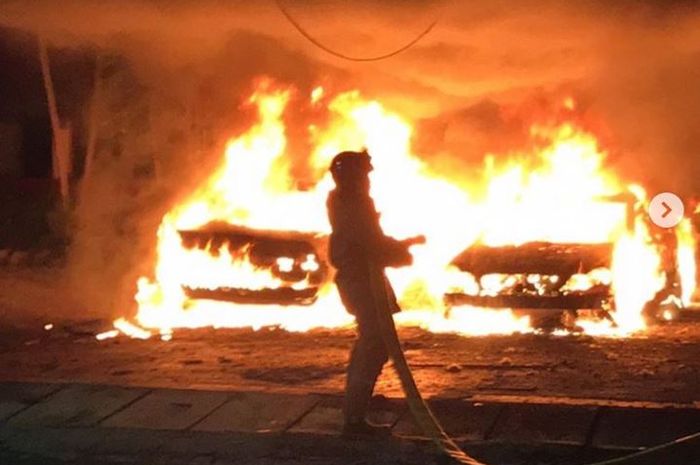 Petugas pemadam kebakaran mencoba memadamkan api yang membakar BMW 520i dan Mercedes-Benz di kawasan Kayu Putih, Pulogadung, Jakarta Timur