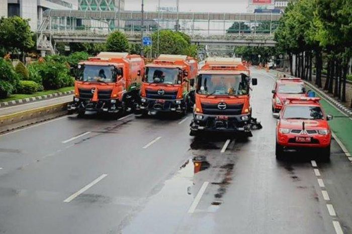 Petugas gabungan menyemprotkan disinfektan di sepanjang jalan Sudirman-Thamrin