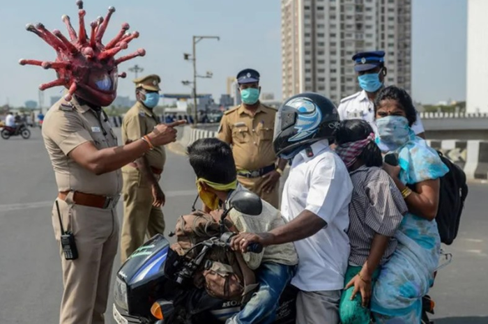 Polisi di India mengenakan helm ala Covid-19 untuk memperingatkan masyarakat tetap berada di rumah (Stay at Home)