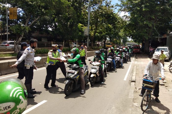 Pembagian bantuan beras kemasan 5 kilogram di Jl. Panjang, Jakarta Barat.