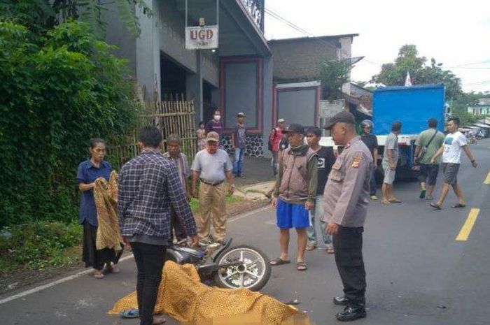 Jasad Tardiyadi dan sepeda motornya tergeletak di tepi jalan, sesaat sebelum diangkut ke Puskesmas Ciawi, Minggu (5/4) 