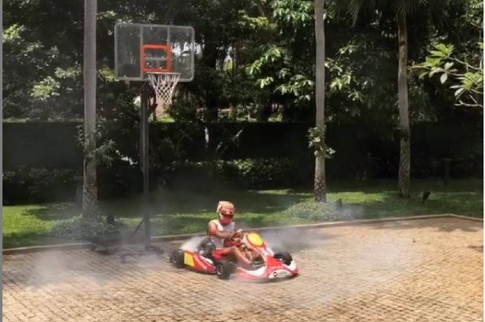 Sean Gelael beraksi dengan gokart di lapangan basket di rumahnya. 