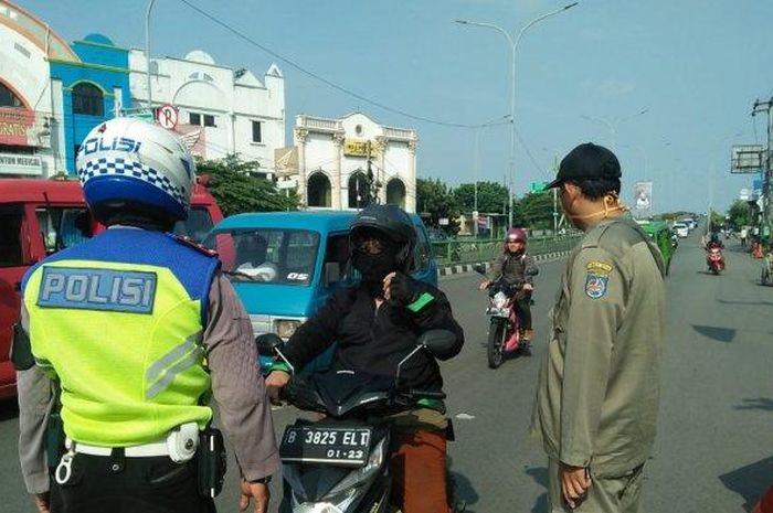 Pengendara motor dicek petugas gabungan persiapan pemberlakuan PSBB di kota Depok, (14/4/20)