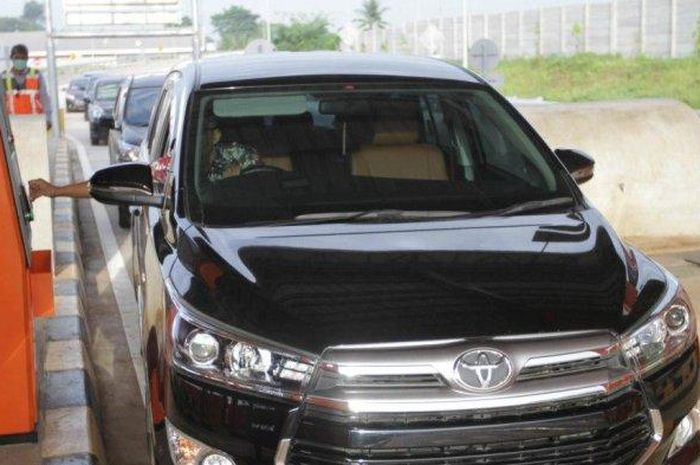 Pengemudi Toyota Kijang Innova sedang melalukan transaksi di gerbang tol Simpang Susun Balaraja Timur, Tangerang