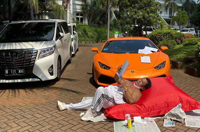 Hotman Paris Hutapea mengunggah foto sedang berjemur dengan ditemani dua mobil mewahnya, Toyota Alphard dan lamborghini Huracan.