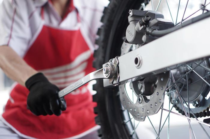 Setel rantai dengan mengendorkan as roda