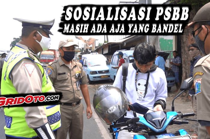 Petugas pengawasan pelaksanaan PSBB sedang memberikan teguran kepada pemotor yang tidak menggunakan masker saat berkendara