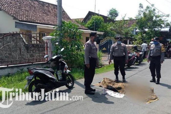 Polisi menutupi jenazah Sutrisno dengan kain jarit, pria di Tulungagung yang mendadak tergeletak di tengah jalan, Rabu (22/4/2020).