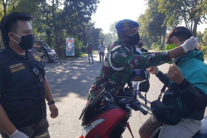 Cakra Rider Bali bersama Denpom IX/3 Denpasar memberikan masker bagi masyarakat di Jalan Raya Niti Mandala Renon Depan Mako Denpom IX/3 Denpasar, Bali, Rabu (22/4/2020). Peduli Covid-19, Cakra Riders Bali Bagi-bagi Masker, Hand Sanitizer dan Mi Instan.
