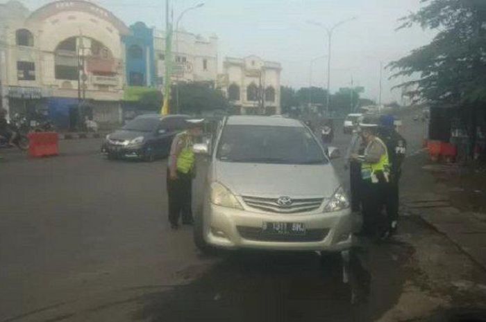 Sebuah TOyota Avanza diperiksa petugas saat diberlakukannya PSBB di Kota Depok