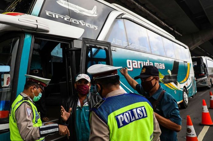 Polisi menghalau bus yang membawa penumpang di jalan tol Jakarta-Cikampek untuk keluar ke Gerbang tol Cikarang Barat, Kabupaten Bekasi, Jawa Barat, Jumat (24/4/2020). 