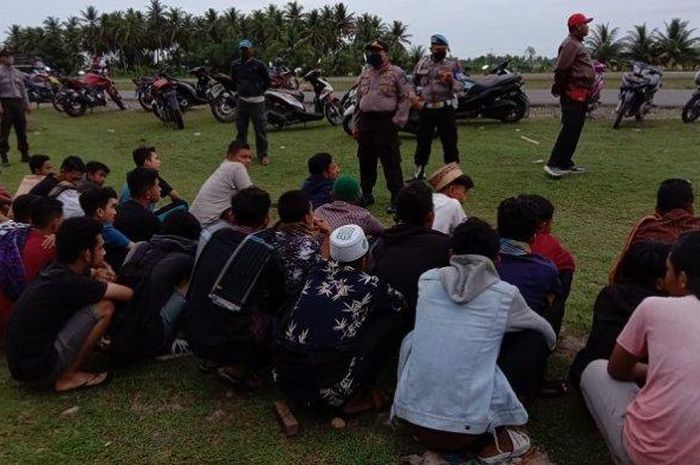 Petugas memberikan arahan kepada remaja yang melakukan balapan liar di lintasan jalan Eks ExxonMobil, Syamtalira Aron -Matangkuli pada Selasa (28/4/2020).