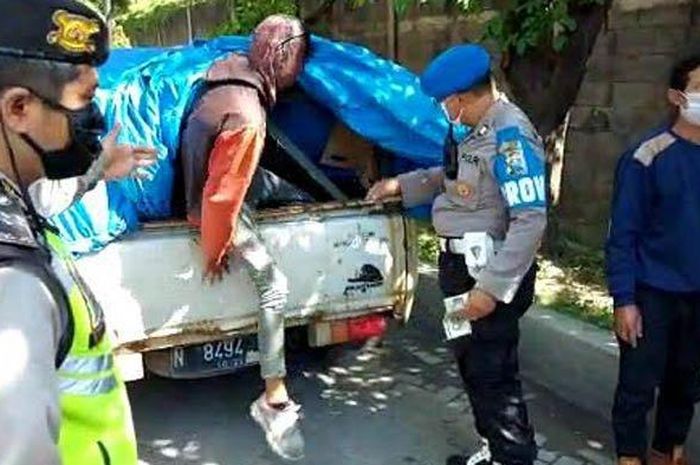 Sebuah mobil Isuzu Panther putih bernopol N 8494 TI dihentikan petugas gabungan karena membawa 5 orang di dalam bak yang ditutup terpal di kawasan SIER Surabaya. 