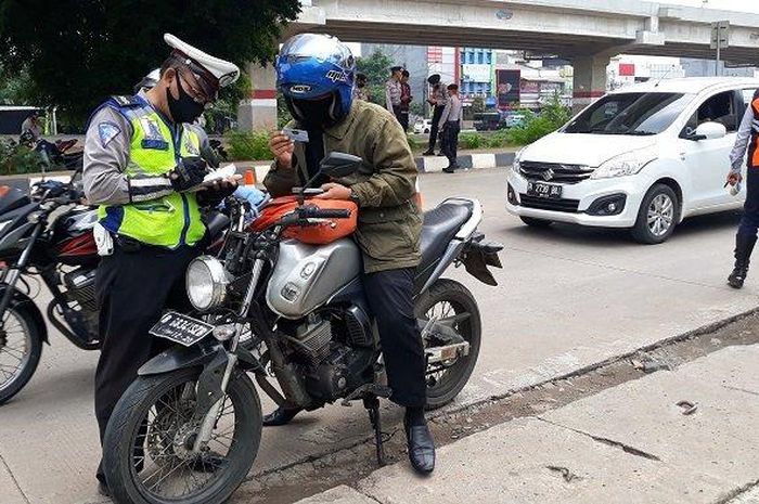 ILUSTRASI - Anggota Polantas mendata pengendara sepeda motor yang tak pakai masker di hari pertama penerapan PSBB Kota Bekasi, Rabu (15/4/2020).