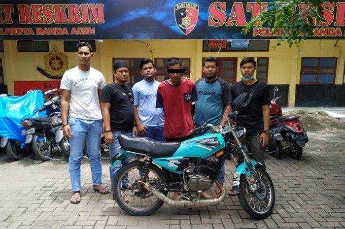 Personel Satuan Reskrim Polresta Banda Aceh, mengapit tersangka DD (mengenakan baju merah) dengan barang bukti sepeda motor Yamaha RX King BL 4455 AZ yang dicuri Sabtu (2/5/2020). 