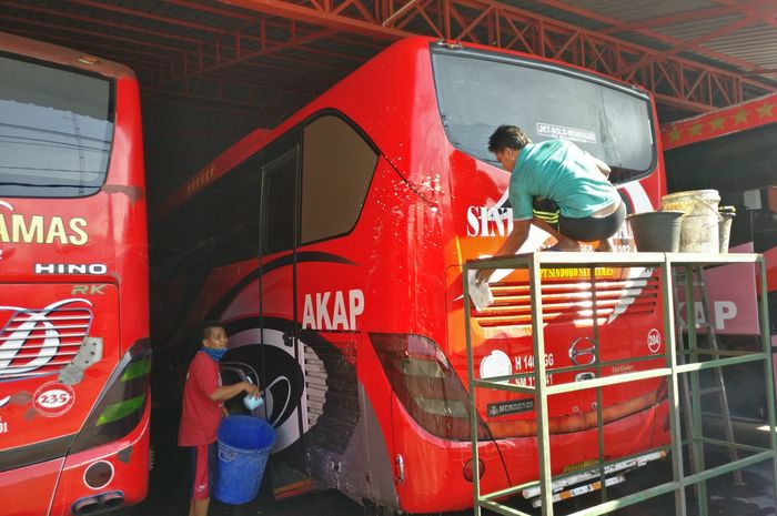 Kru PO Sindoro Satriamas yang sedang membersihkan bus karena dirumahkan