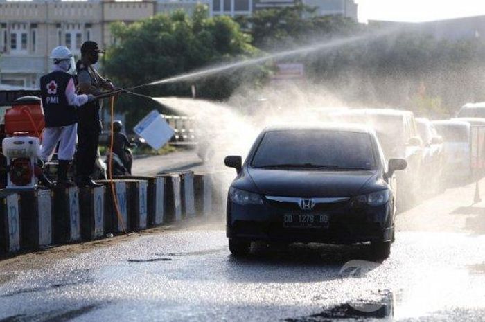 Petugas gabungan menyomprotkan cairan disinfektan kepada pengendara yang memasuki ke Kabupaten Gowa di perbatasan Gowa-Makassar, Jl Tun Abd Razak, Kabupaten Gowa, Sulawesi Selatan, Sabtu (2/5/2020). Penyomprotan tersebut untuk mencegah penyebaran virus corona (Covid-19) dan mengimbau pengguna jalan tentang aturan Pembatasan Sosial Berskala Besar (PSBB) di Gowa yang akan diterapkan pada Senin (4/5/2020).