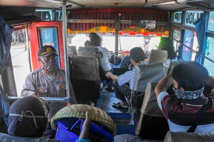 Petugas kepolisian mengecek angkutan umum yang melintas di Kedungwaringin, Kabupaten Bekasi, Jawa Barat, Minggu (3/5/2020). Penjagaan dilakukan untuk melarang pemudik dari kawasan Jabodetabek melintasi wilayah Bekasi. 