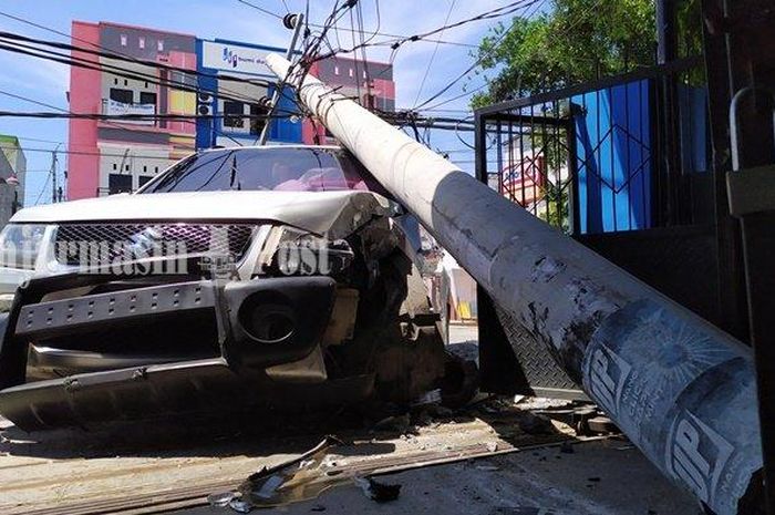 Suzuki Grand Vitara tertimpa tiang listrik ketika melaju di Jl Skip Lama, Teluk Dalam, Banjarmasin Tengah, Banjarmasin, Kalimantan Selatan