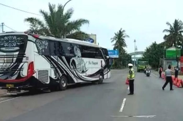 Petugas Polres Tuban saat menghalau rombongan bus pengangkut pemudik agar putar balik, saat memasuki Provinsi Jatim di Kecamatan Bancar. Polres Tuban tetap akan memantau ketat meski bus-bus kembali diperbolehkan beroperasi.