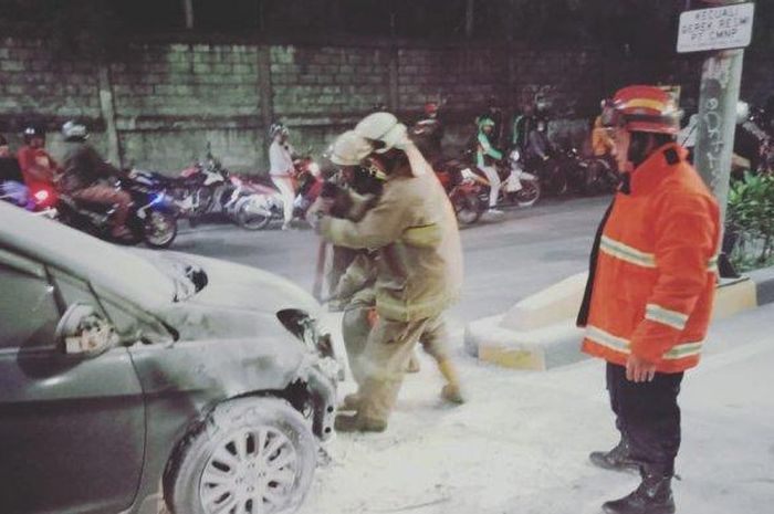 Proses pemadaman mobil yang terbakar di dekat GT Rawamangun, Jalan Ahmad Yani, Jakarta Timur, Jumat (8/5/2020). 