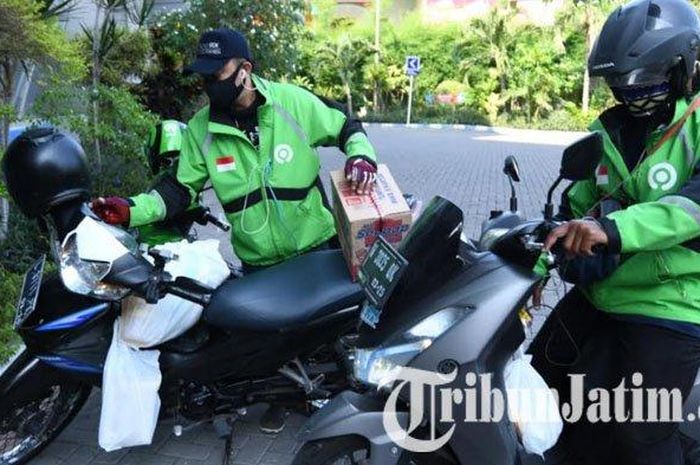 Driver ojek online mengantarkan pesanan dari transaksi di Lumbung Pangan Jatim di Jatim Expo Surabaya, Jumat (8/5/2020). 
