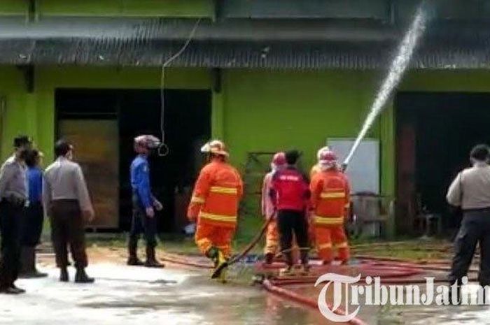 Petugas pemadam menyemprotkan air di gudang pertanian di BPP Karangan, Kabupaten Trenggalek, Selasa (12/5/2020). 
