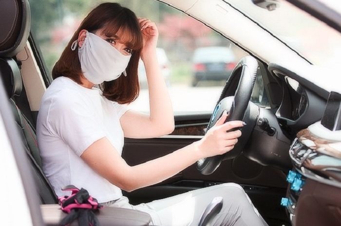 Ilustrasi. Mengendarai mobil pakai masker.