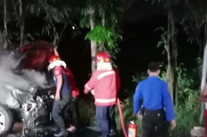 Petugas Damkar Kota Madiun melakukan pembasahan mobil yang terbakar di Ring-road Barat, Kota Madiun  