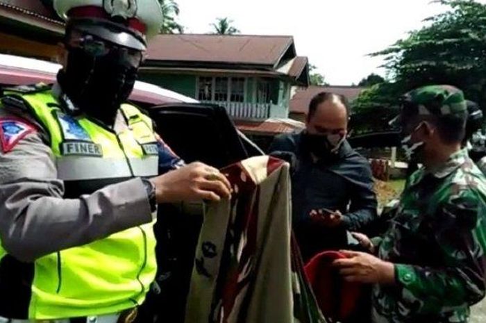 Petugas saat memeriksa seorang lelaki yang akan masuk ke Kota Padang, Rabu (13/5/2020).