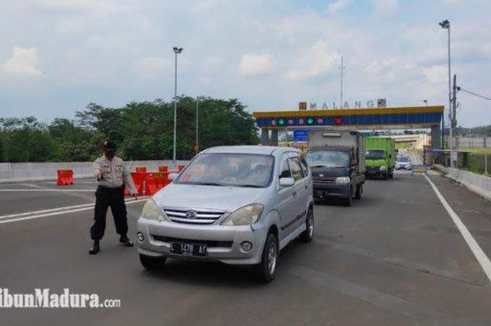 Petugas di pos check point gerbang Tol Madyopuro meminta kendaraan pelat luar Kota Malang untuk putar balik, Sabtu (16/5/2020)