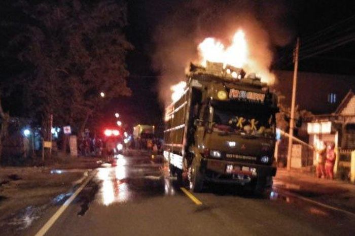 Petugas saat memadamkan api yang membakar truk di jalan Desa Golokan, Kecamatan Sidayu, Kabupaten Gresik, Sabtu (16/5/2020 dini hari.