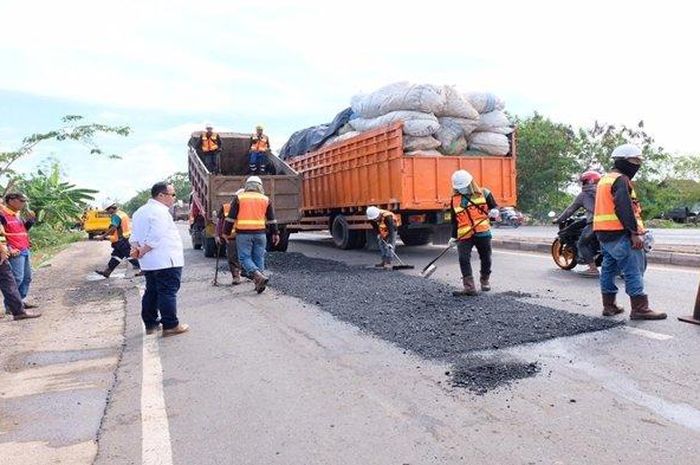 Para pekerja dari Balai Besar Pelaksana Jalan Nasional (BBPJN) Wilayah V tampak tengah melakukan perbaikan jalan di Jalan Lintas Sumatera, Sabtu (16/5/2020).