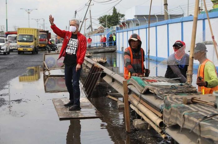 Gubernur Jawa Tengah, Ganjar Pranowo, saat mengatur lalu lintas di lokasi banjir rob, Sabtu (16/5)