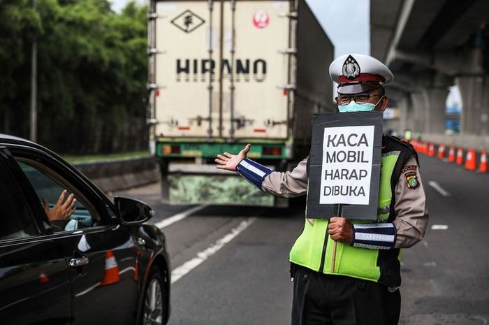  Polisi melakukan himbauan kepada penumpang yang melewati jalan tol Jakarta-Cikampek di Kabupaten Bekasi, Jawa Barat, Jumat (24/4/2020).