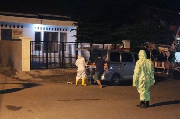 Petugas mengenakan APD lengkap saat mengevakuasi jenazah pria yang ditemukan meninggal dunia di simpang tiga Pasar Lama, Desa Mertapada Kulon, Kecamatan Astanajapura, Kabupaten Cirebon, Rabu (20/5/2020) dinihari. 