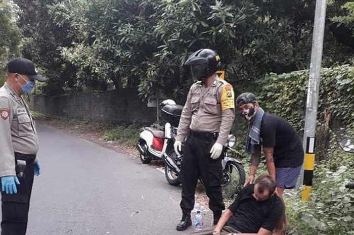 Petugas kepolisian dibantu warga sekitar saat mengevakuasi jenazah korban kecelakaan tunggal di Tulamben, Rabu (20/5/2020) kemarin  