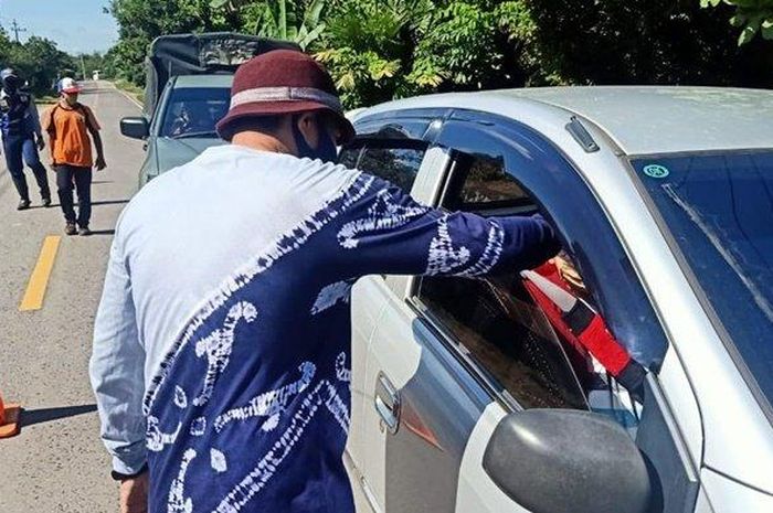 Petugas memeriksa pengendara yang melintas di pos batas Padang Panjang, Kabupaten Tabalong, Kalimantan Selatan,  Kamis (21/5/2020) pagi.