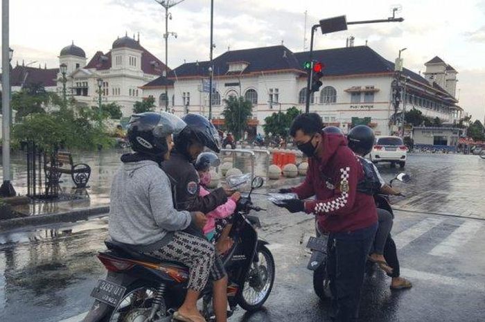 Anggota YNCI Yogyakarta Chapter, saat membagikan masker di ruas jalan titik nol kilometer Kota Yogyakarta, Rabu (20/5/2020).