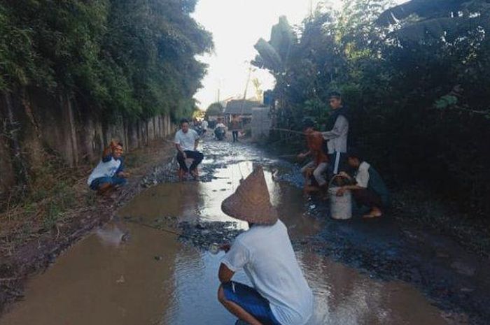 Sejumlah warga gelar aksi memancing sebagai protes atas jalan rusak di Kampung Ciawet Pasir Waru RT 011/RW 002 Desa Majasari Kecamatan Jawilan Kabupaten Serang, Banten, pada Senin (25/5/2020). 