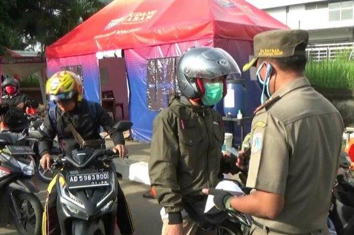 Petugas gabungan saat memeriksa kelengkapan SIKM di Jalan Raya Bekasi, Cakung, Jakarta Timur, Selasa (26/5/2020). 
