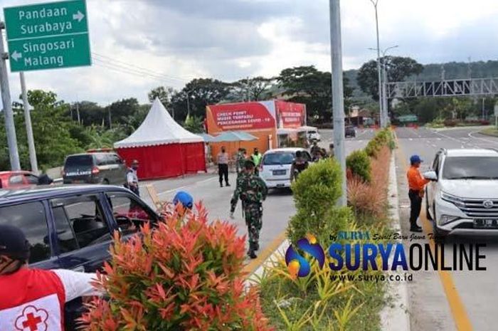 Petugas memberhentikan mobil pribadi yang melintasi Posko Check Point Exit Tol Lawang, Senin (25/5/2020). Tampak di sebelah kanan sebuah mobil plat L memutar balik lantaran hingga kini PSBB Malang Raya masih berlaku. 