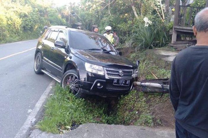 Suzuki Grand Vitara terjang motor dan tiang kabel telepon hingga nyungsep di got